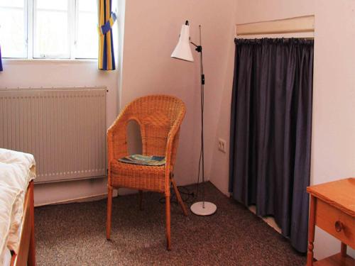 a bedroom with a chair and a lamp in a room at Gut Karlsminde in Waabs