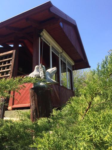 a house with a statue of a dog on the porch at Holiday home Nanin konak 2 in Vrdnik