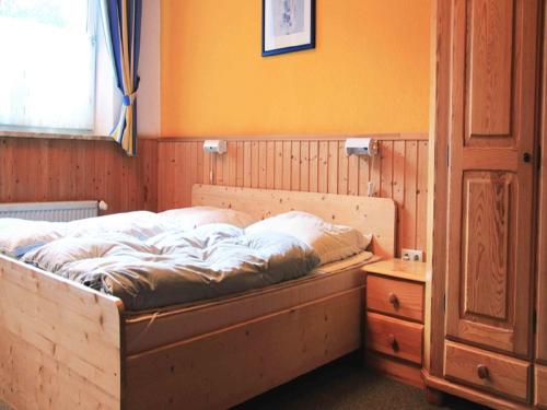 a bed in a bedroom with an orange wall at Gut Karlsminde in Waabs