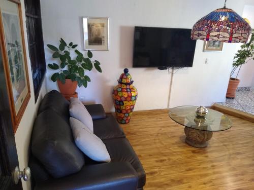 a living room with a black leather couch and a table at Hotel Villa Del Sol Expo in Guadalajara