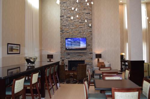a living room with a fireplace and a tv on a wall at Holiday Inn Express & Suites Geneva Finger Lakes by IHG in Geneva