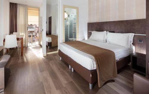 a hotel room with a bed and a dining room at Residence Queen in Rimini
