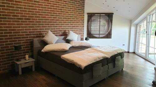 Ce lit se trouve dans une chambre dotée d'un mur en briques. dans l'établissement Ferienwohnung Sofia, à Papenbourg