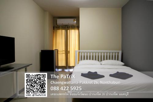 a bedroom with a bed and a television and a window at The PaTriX Chaengwattana in Nonthaburi