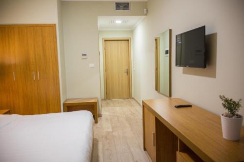 une chambre d'hôtel avec un lit et une télévision dans l'établissement Hotel Jaroal, à Saranda