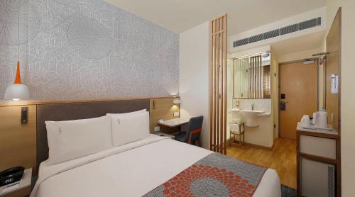 a hotel room with a bed and a bathroom at Holiday Inn Express Pune Hinjewadi, an IHG Hotel in Pune