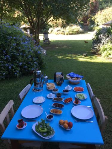 uma mesa azul com pratos de comida em Emel Pension em Güzelçamlı