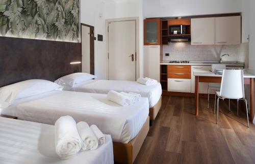 a hotel room with two beds and a kitchen at Residence Queen in Rimini
