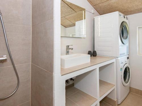 une salle de bain avec un lavabo et une machine à laver dans l'établissement Luxury Retreat with Pool - By Traum Ferienwohnungen, à Sønderby