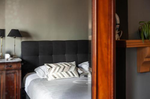 a bed with a black headboard and two pillows at B&B La Passion Interdite in Ostend
