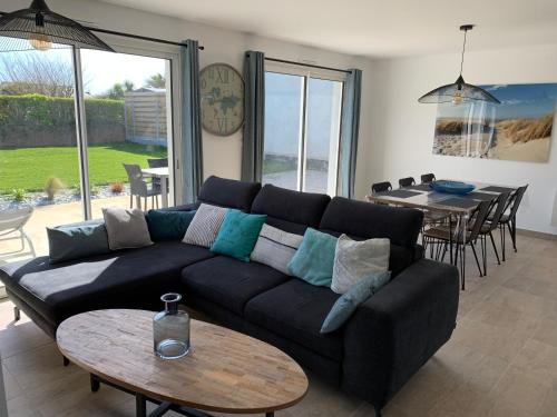a living room with a black couch and a table at La maison Ti Billou in Santec