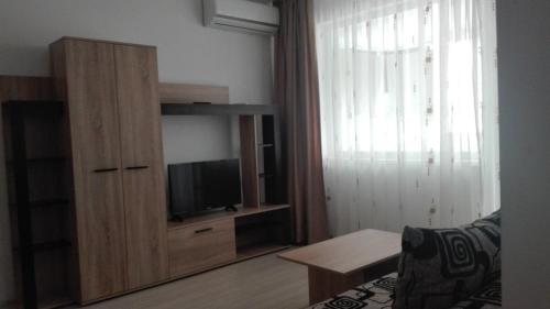a living room with a television and a entertainment center at Apartament City in Constanţa