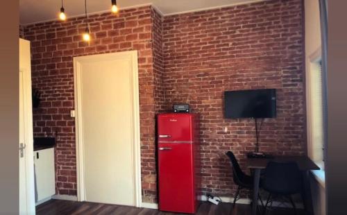 a brick wall with a red refrigerator next to a door at Queens Beachhouse in Zandvoort