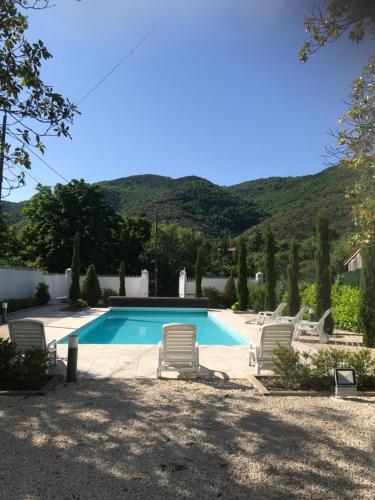 - une piscine avec chaises longues dans la cour dans l'établissement Le Petit Chateau, à Puilaurens