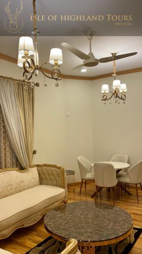 a living room with a couch and a table at ISLE OF HIGHLAND TOURS Guest House in Gilgit