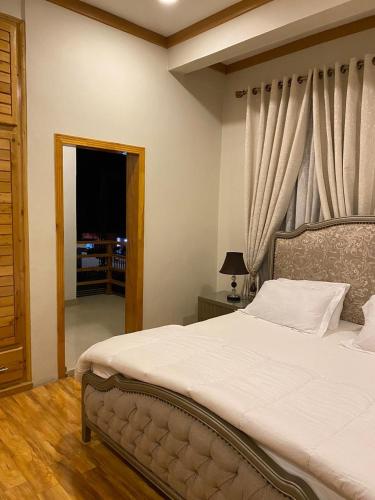 a bedroom with a large bed with a window at ISLE OF HIGHLAND TOURS Guest House in Gilgit