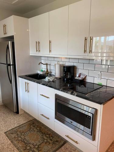 a kitchen with white cabinets and a black counter top at Captiva Beach Resort (open private beach access) in Sarasota