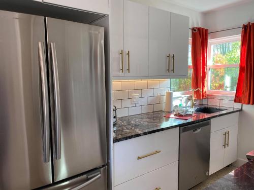 a kitchen with white cabinets and a stainless steel refrigerator at Captiva Beach Resort (open private beach access) in Sarasota