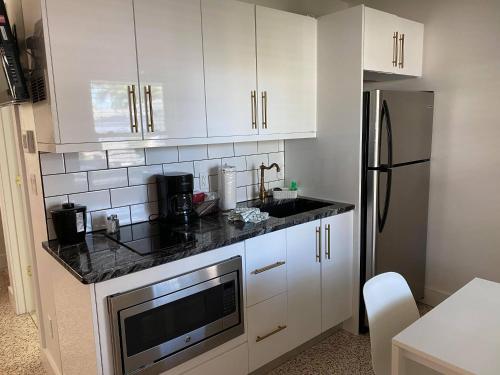 a kitchen with white cabinets and white appliances at Captiva Beach Resort (open private beach access) in Sarasota