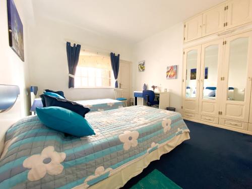 a bedroom with a bed with blue pillows at Vivenda Cinco Palmeiras - Na serra de Monchique in Monchique