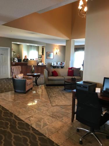 a living room with a couch and a table at GrandStay Hotel & Suites Ames in Ames