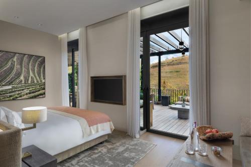 a bedroom with a large bed and a large window at Six Senses Douro Valley in Lamego