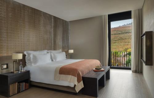 a bedroom with a large bed and a large window at Six Senses Douro Valley in Lamego