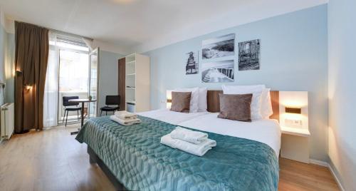 ein Schlafzimmer mit einem großen Bett mit Handtüchern darauf in der Unterkunft Hotel Duinlust in Domburg