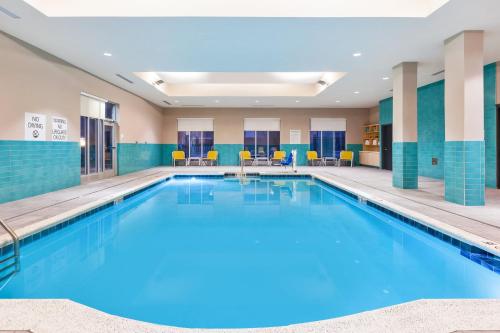 Holiday Inn & Suites - Toledo Southwest - Perrysburg, an IHG Hotel في بيرسبورغ: مسبح كبير في غرفة الفندق بلاط ازرق