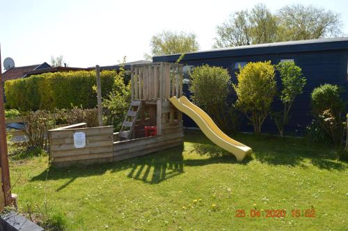 a playground with a slide in a yard at Vakantie Chalet Makkum in Makkum