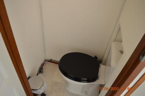 a small bathroom with a toilet with a black seat at Vakantie Chalet Makkum in Makkum