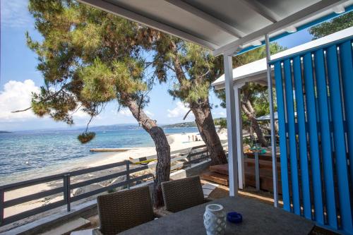 a view of the beach from the porch of a beach house at OURANOUPOLI BUNGALOWS & CAMPING in Ouranoupoli