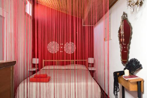 a red room with a bed and red curtains at Flat 13 in Catania