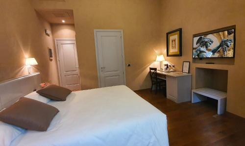 a bedroom with a large white bed and a desk at B&B La Signoria Di Firenze in Florence