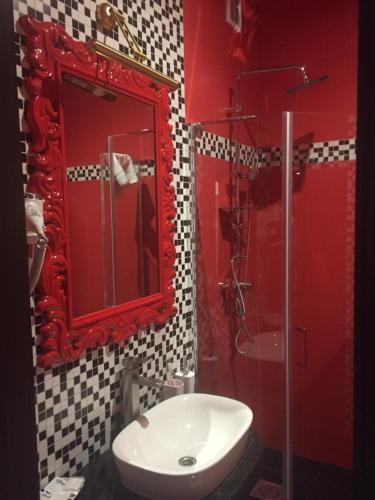 a bathroom with a red mirror and a sink at Готель Ангел на Великій Кільцевій in Kyiv