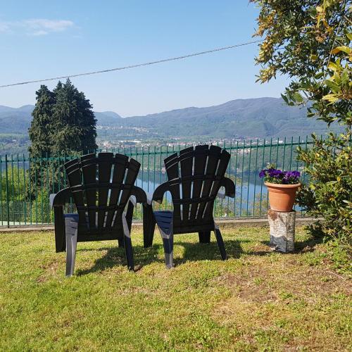 two black chairs sitting in the grass in front of a fence at Villa Le Vignole in Ameno