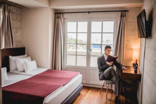 a man sitting at a desk in a hotel room at Palla Boutique Hotel in Arequipa