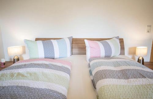 a bedroom with two beds with pillows and two lamps at Ferienwohnung Kienast in Pfons