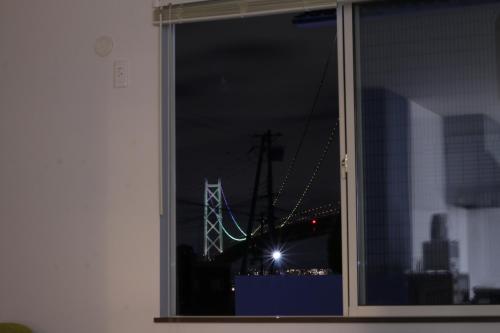 a window with a view of a bridge at night at Tiz wan 岩屋あわじ in Awaji