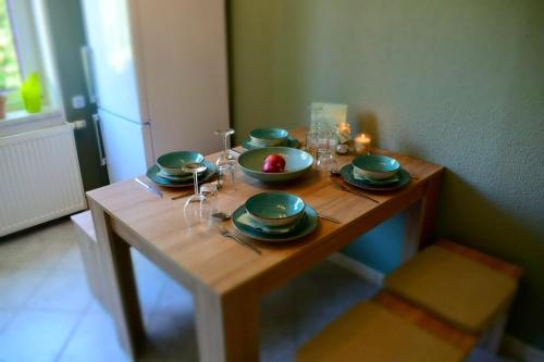 una mesa de madera con platos y vasos. en Ferienwohnung Jüdel mit Saunanutzung, en Beierfeld