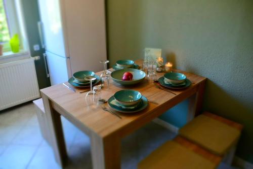 a wooden table with plates and glasses on it at Ferienwohnung „Jüdel“ in Beierfeld