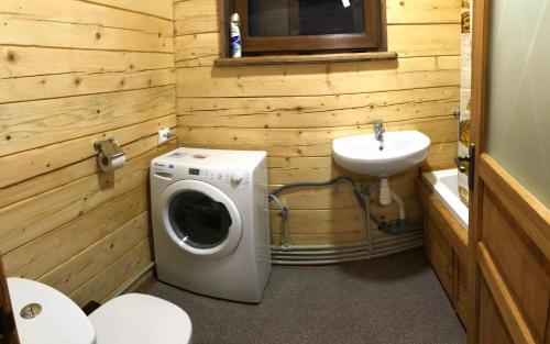 a bathroom with a washing machine and a sink at Kozichky Guest House in Tatariv