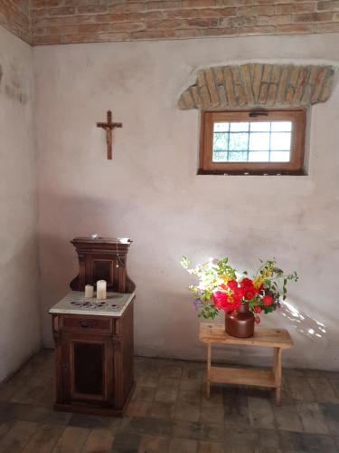 a room with a cross and a table with flowers at Kétbodonyi Apartments in Kétbodony