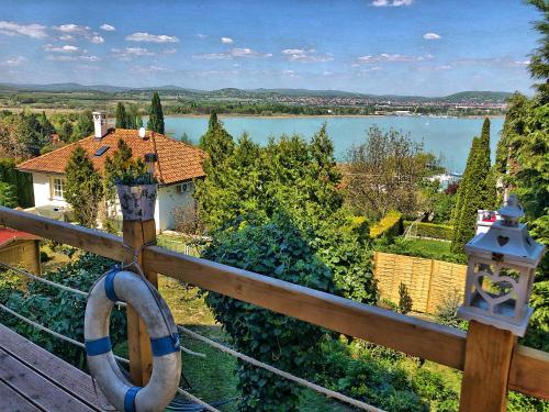 a balcony with a view of a house and a lake at Villa Borostyán in Tihany