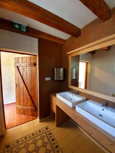 baño con 2 lavabos y espejo grande en Hotel KORTUS en Jetřichovice