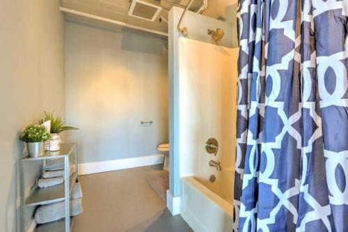 a bathroom with a shower curtain and a tub at Vogue loft walk to CityMu/Cards/Aquarium/ConvCtr in Saint Louis