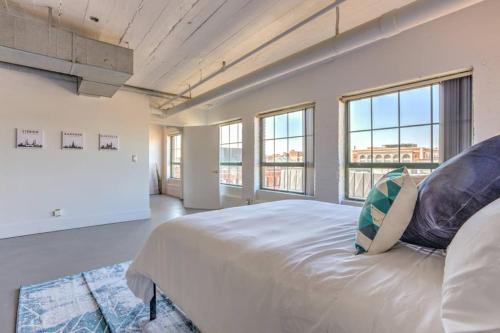 a large bedroom with a large bed and windows at Vogue loft walk to CityMu/Cards/Aquarium/ConvCtr in Saint Louis