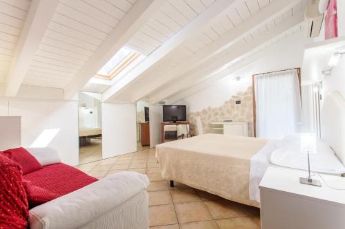 a large bedroom with a bed and a couch at Hotel Flora in Milano Marittima