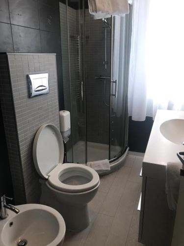 a bathroom with a shower and a toilet and a sink at Hotel Flora in Milano Marittima
