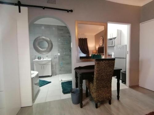 uma casa de banho com uma mesa preta e um chuveiro em Roxy's Rest Guest House em Vanderbijlpark